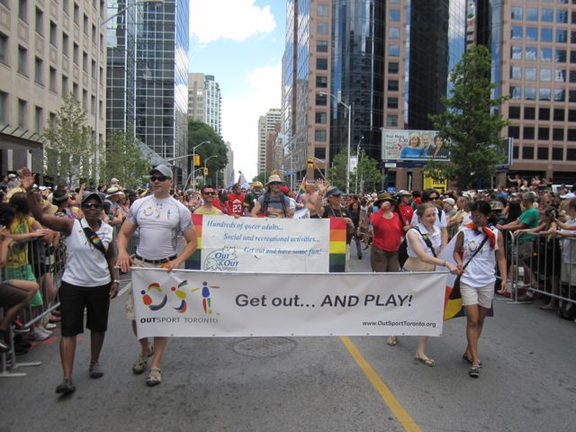 OutSport Toronto directors carrying the banner in front of the sport and rec contingent in the parade.